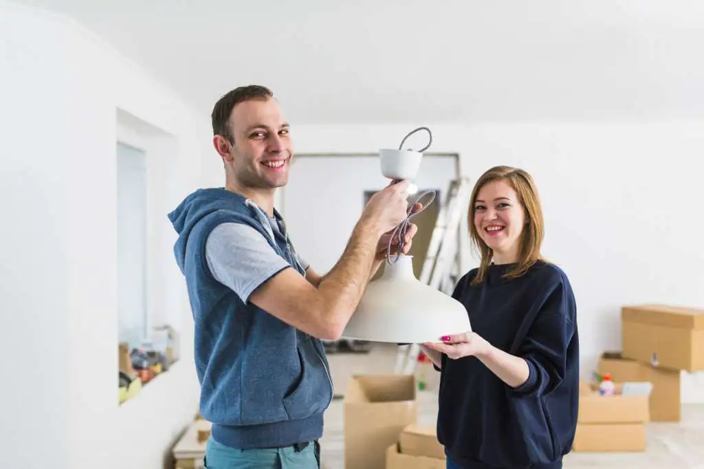cheerful-couple-installing-lamp_23-2147782381