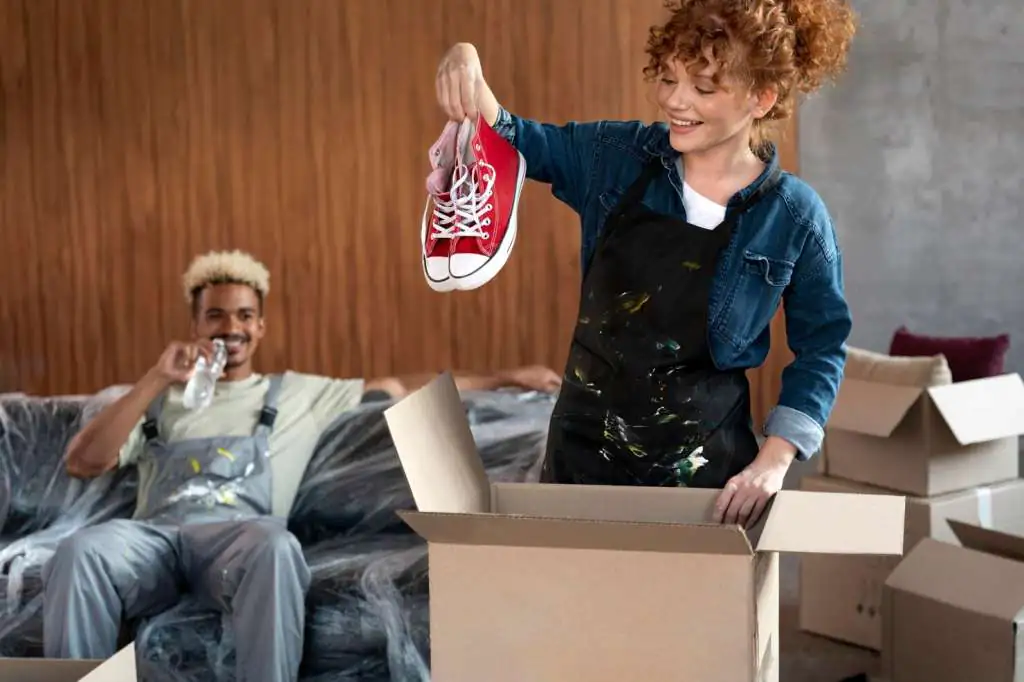 couple-sorting-belongings-from-cardboard-boxes-after-moving-new-home_23-2149086887
