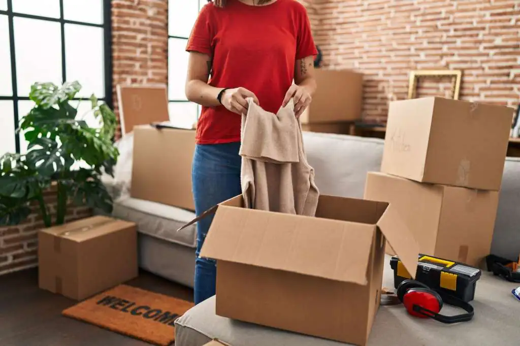 young-beautiful-hispanic-woman-unpacking-cardboard-box-new-home_839833-33657