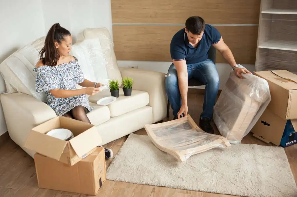 young-couple-moving-new-home-unpacking-carboard-boxes-almost-done-moving_482257-24142