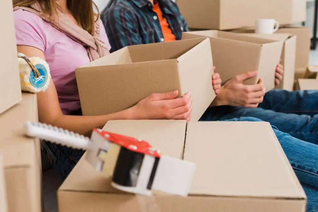 How to Pack Boxes for Moving: The Ultimate Step-by-Step Guide-2 close-up-young-couple-holding-cardboard-boxes-hand-their-new-house_23-2148095524