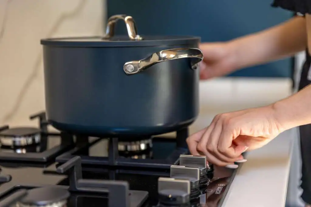 How to Pack Pots for Moving: Step-by-Step-3 human-hand-turns-stove-knob-with-pot-burner-cooking-process_169016-70956